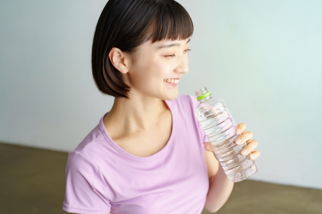 笑顔で水を飲む女性